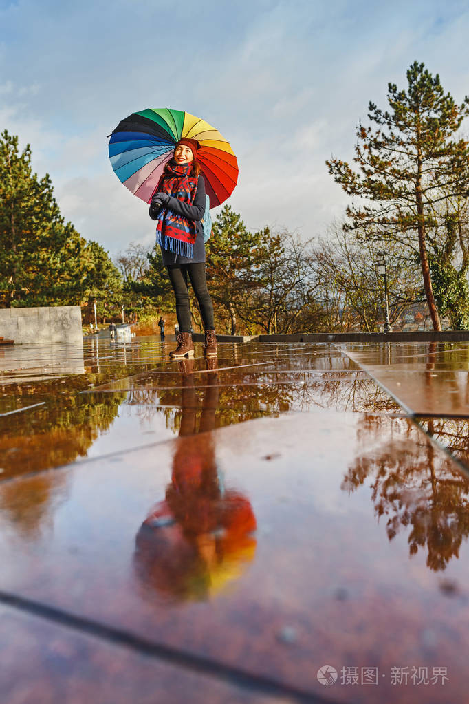 雨天带雨伞的女子在公园的森林小路上行走
