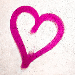桃红色心脏在混凝土墙壁