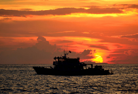 海中渔船的剪影与太阳背景