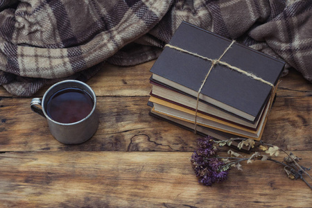 金属杯热茶或咖啡, 暖格子, 一堆书 Ti