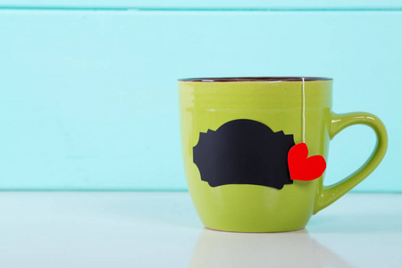 用一颗心形的茶叶标记的绿色杯子