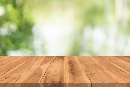 张木桌顶上自然绿色模糊背景，蒙太奇为您的产品