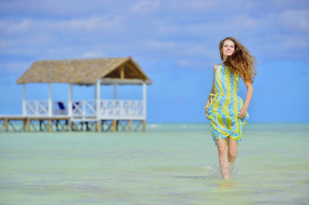 穿裙子的女人在海洋中的沙洲上。 沙滩上可爱的年轻女孩。 年轻女士在海滩上摆姿势。 户外放松休闲理念。 古巴。 卡亚可可。
