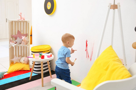家中的小男孩在墙上画画