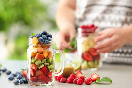 桌上的浆果和水果玻璃瓶
