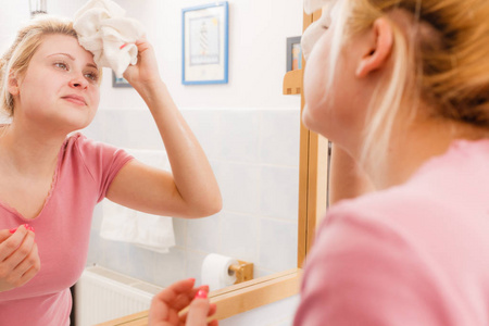 用白色毛巾清洗后擦脸的女人照片