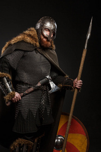 维京人盾和斧战士维京在充分的胳膊用斧头,盾和长矛在黑暗 b照片