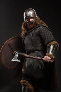 斧头剑战士维京在充分的胳膊用斧头和盾在黑暗的 backgrou照片