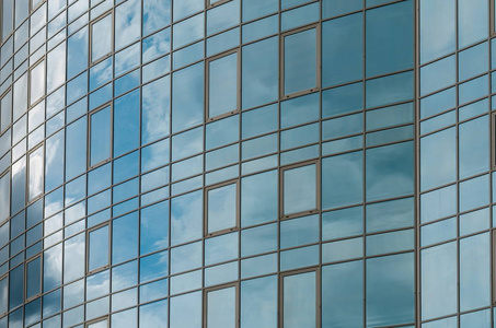 摩天大楼镜面玻璃表面反射多云的天空弯曲的表面