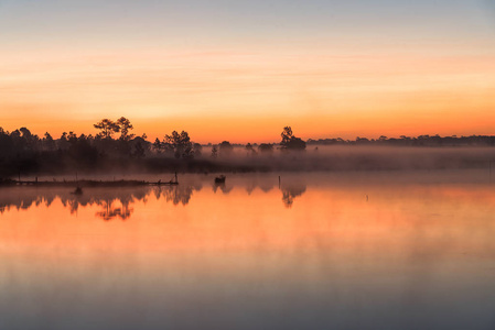 早晨日出在湖与剪影树反射在水表面在富 Kradaung, 国家公园在泰国