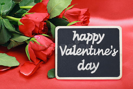 玫瑰和一块写着祝贺的黑板情人节快乐