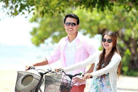 海滩上骑自行车的年轻夫妇画像