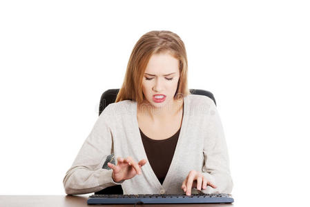 漂亮随意的女人生气地在键盘上写字。