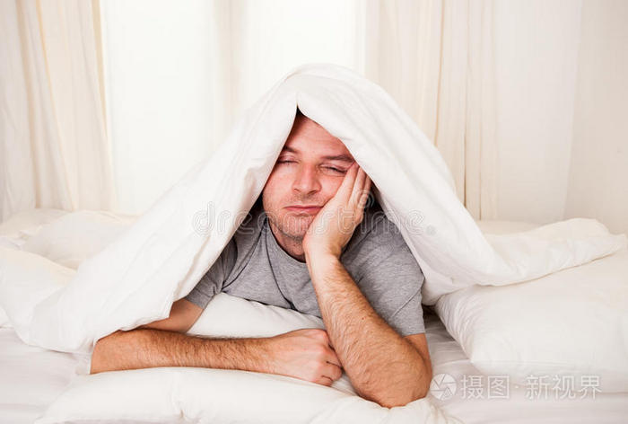 躺在床上睁开眼睛的男人患有失眠和
