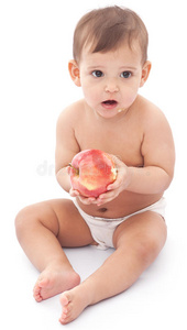 有趣的婴儿和苹果坐在地板上。