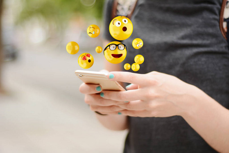 女人使用智能手机发送 emojis