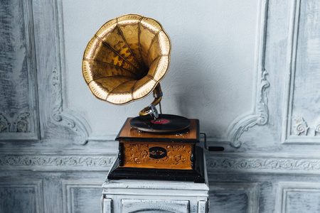 老记录播放器反对古木墙。古董留声机与复古板产生悦耳的声音或音乐。立体声系统。和音响技术概念