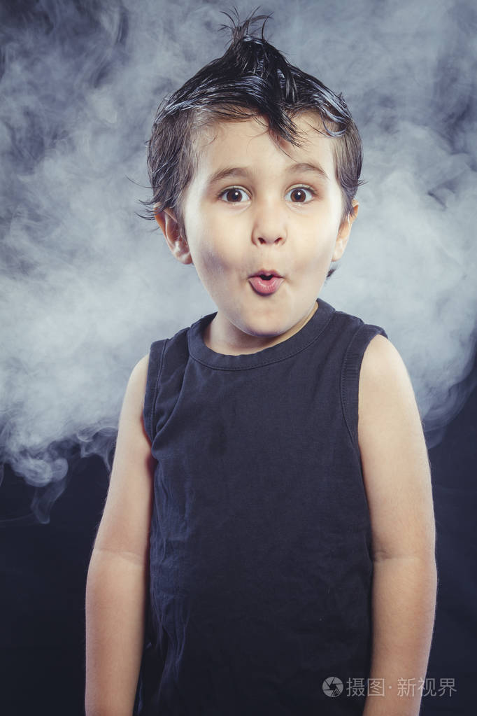 令人惊讶的男孩有滑稽的头发冠和摇臂的外观