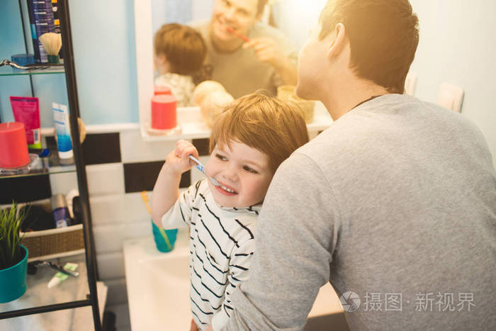 年轻的父亲与他的儿子刷牙