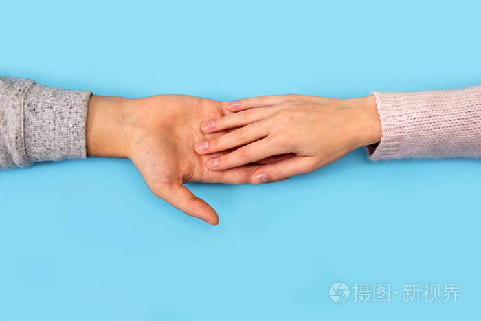 女人的手在蓝色背景上伸向男人的手