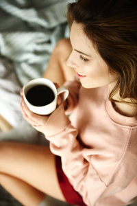 女人在卧室里拿着咖啡杯