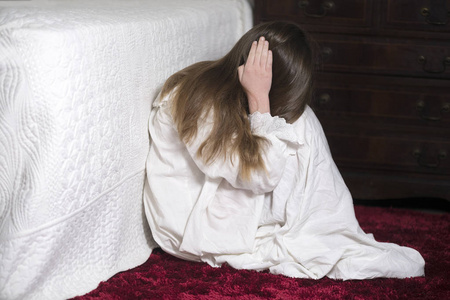 年轻的不可辨认的女孩是一个富裕的卧室,她双手捂住耳朵,阻止争论,并