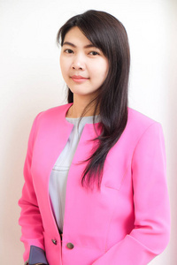商务亚洲女性穿着粉红色西装，在白色背景下独立站立