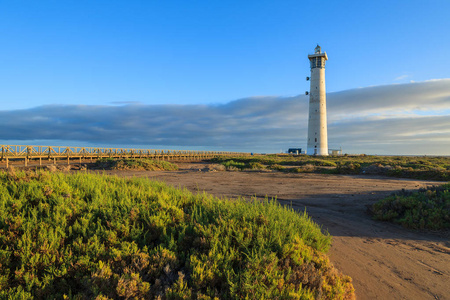 詹迪亚半岛莫罗杰布尔海滩灯塔在日落光线下，费特文图拉加那利岛，西班牙