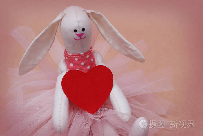 玩具兔子与红色心脏藏品。明信片到情人节。母亲节。粉红色背景