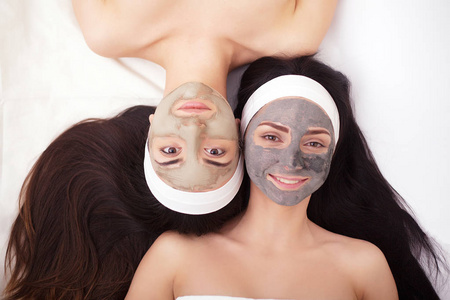 在一家美容院的脸两个年轻女性的脸面膜使用