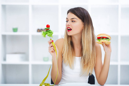 节食概念, 美丽的少妇选择在健康之间