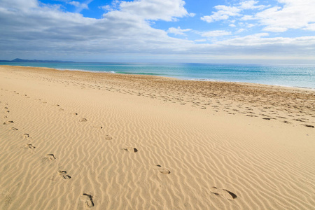 在沙滩上的脚印，在詹迪亚海滩上美丽的绿松石海，莫罗杰布尔费埃特文图拉加那利群岛，西班牙