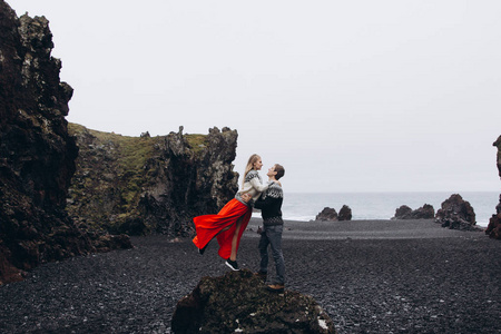 年轻夫妇站在岩石上拥抱