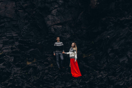 年轻夫妇手牵手洞穴背景