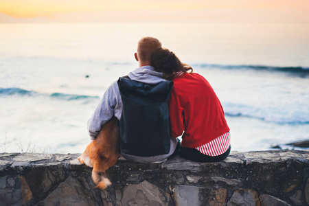 情侣拥抱背景海滩海洋日出剪影两个浪漫的人拥抱和仰望后景傍晚海景潮