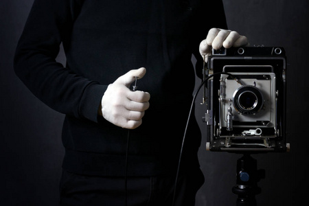 摄影师在白色手套拍摄的照片在一个复古相机