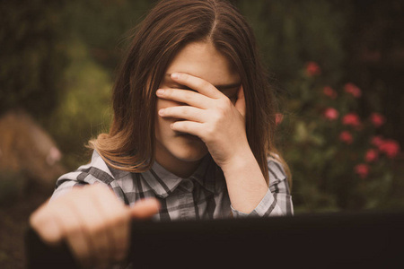 伤心绝望年轻伤心的脆弱女孩使用手机害怕和绝望痛苦在线滥用网络欺凌