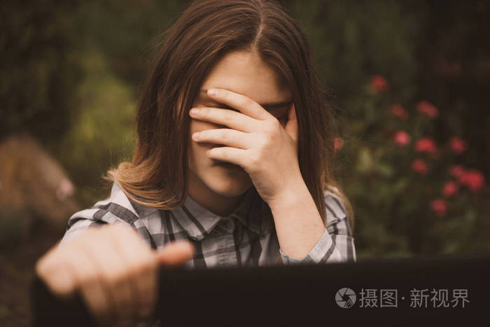 年轻伤心的脆弱女孩使用手机害怕和绝望痛苦在线滥用网络欺凌被跟踪和