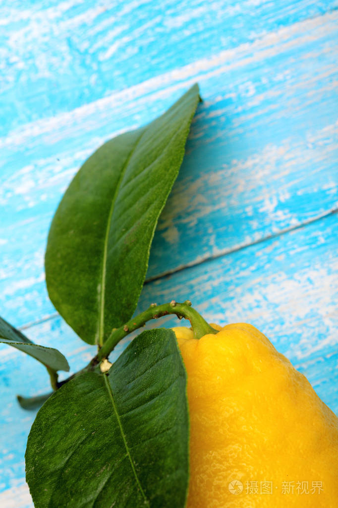 柠檬叶.在青色木桌上, 背景.巨大的柠檬特写. 复制空间