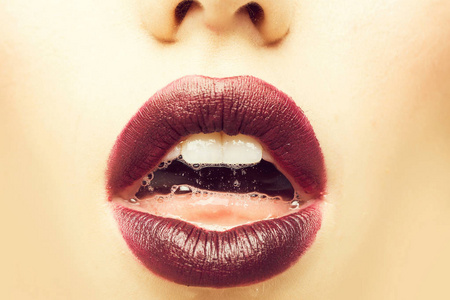 女性张开嘴，嘴唇紫色口红和舌头