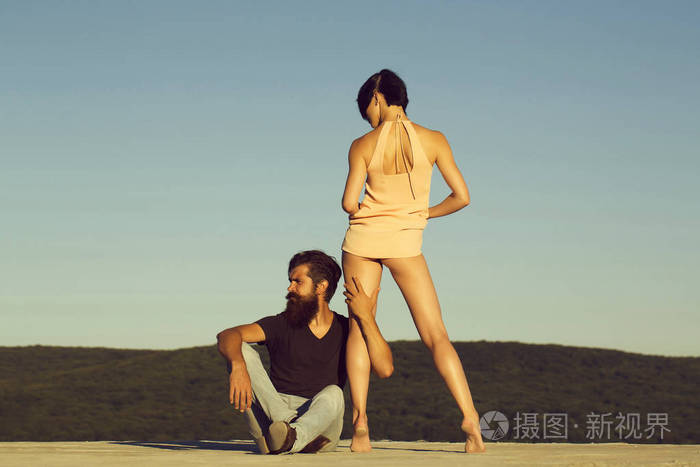 年轻性感的一对黑发女人,漂亮的脸和英俊的留胡子的男人,在蓝天背景在
