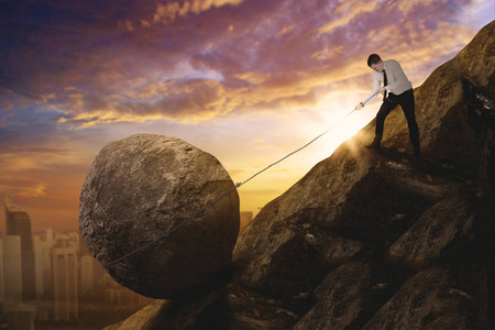 高加索商人在悬崖上拉一块石头照片