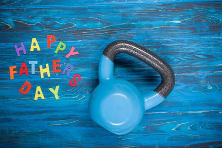 s Day inscription with kettlebell on wooden table