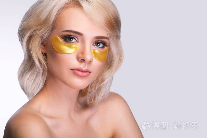 眼罩下的眼睛.美丽的女人脸, 金色的水凝胶 patche