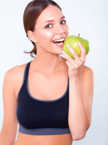 幸福的年轻女人吃苹果，在白色背景上孤立