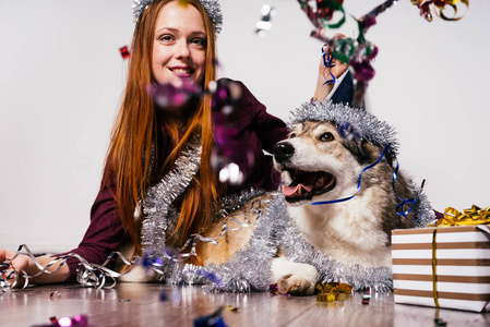 快乐的女人在圣诞帽旁边坐着一只狗