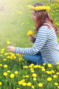 在一个晴朗的日子，在草地上的黄色的蒲公英上休息的女孩