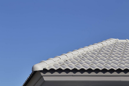 蓝天上的灰色瓷砖屋顶。 建筑建筑物对角线抽象背景
