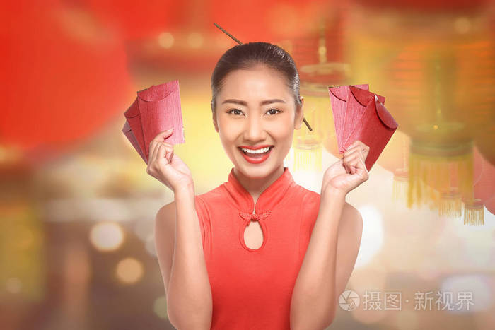 穿旗袍的年轻中国女人拿着红包在灯笼背景上
