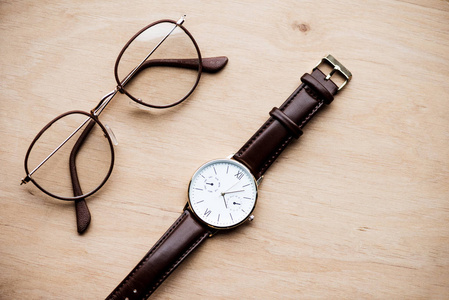 木制表面的眼镜和手表的俯视图